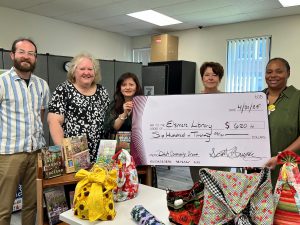 Group of Librarians holding large check smiling at camera